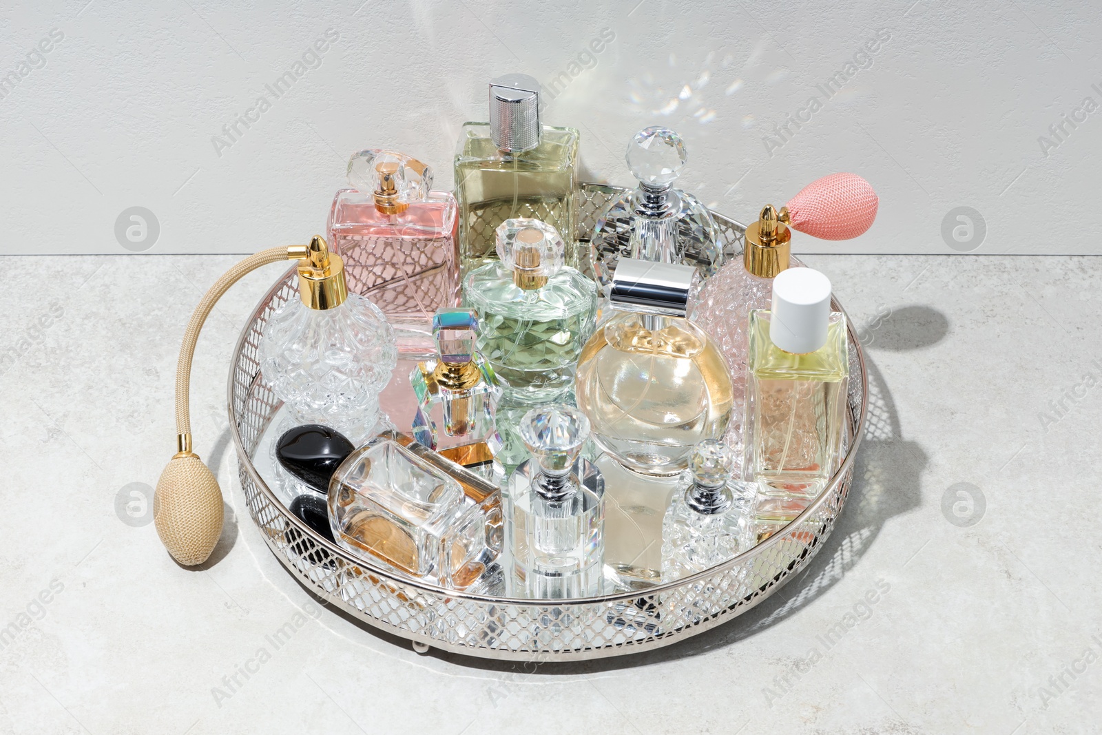 Different luxury perfumes and accessories on light textured table Photo of Different luxury perfumes and accessories on light textured table