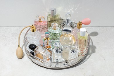 Photo of Different luxury perfumes and accessories on light textured table