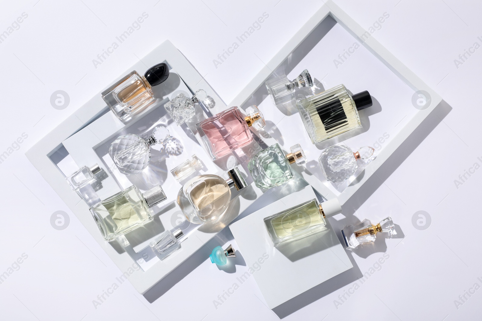 Different luxury perfumes on white background, flat lay Photo of Different luxury perfumes on white background, flat lay