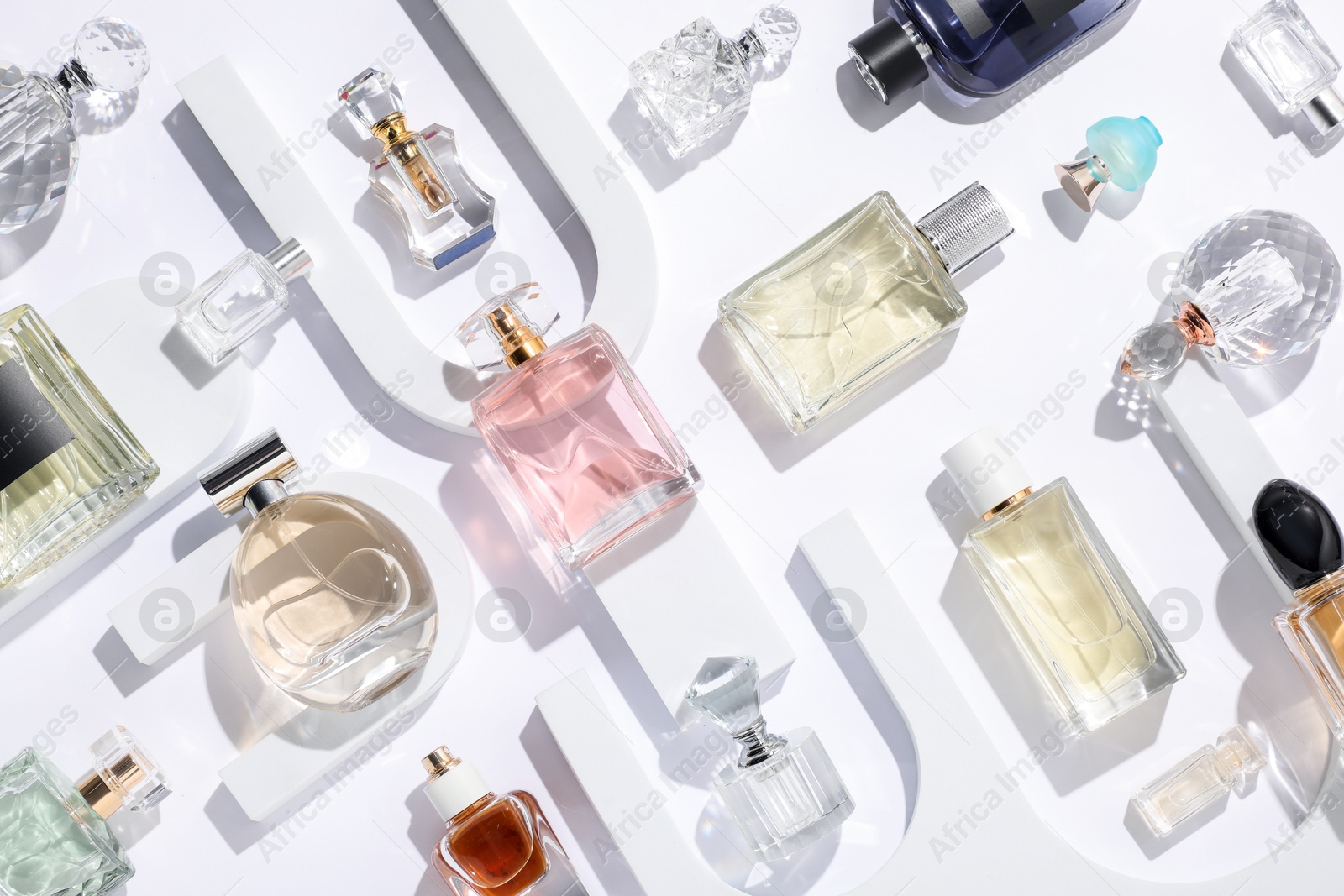 Different luxury perfumes on white background, flat lay Photo of Different luxury perfumes on white background, flat lay