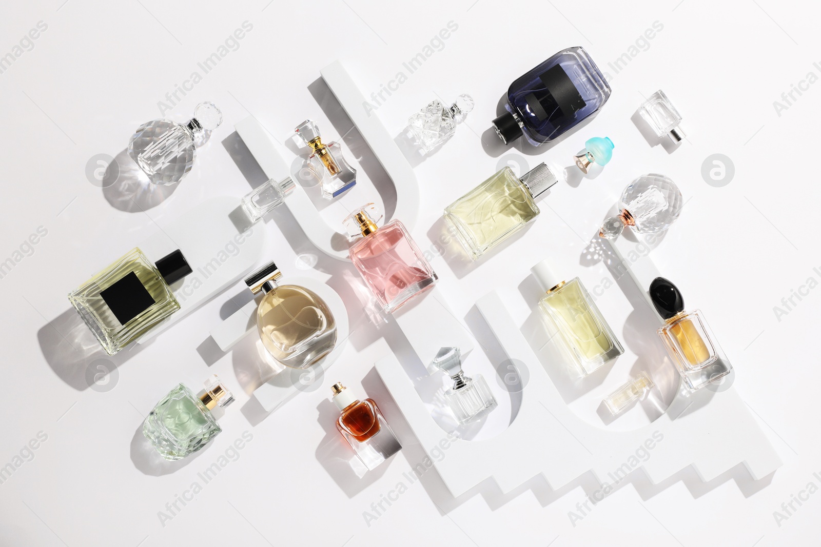 Different luxury perfumes on white background, flat lay Photo of Different luxury perfumes on white background, flat lay