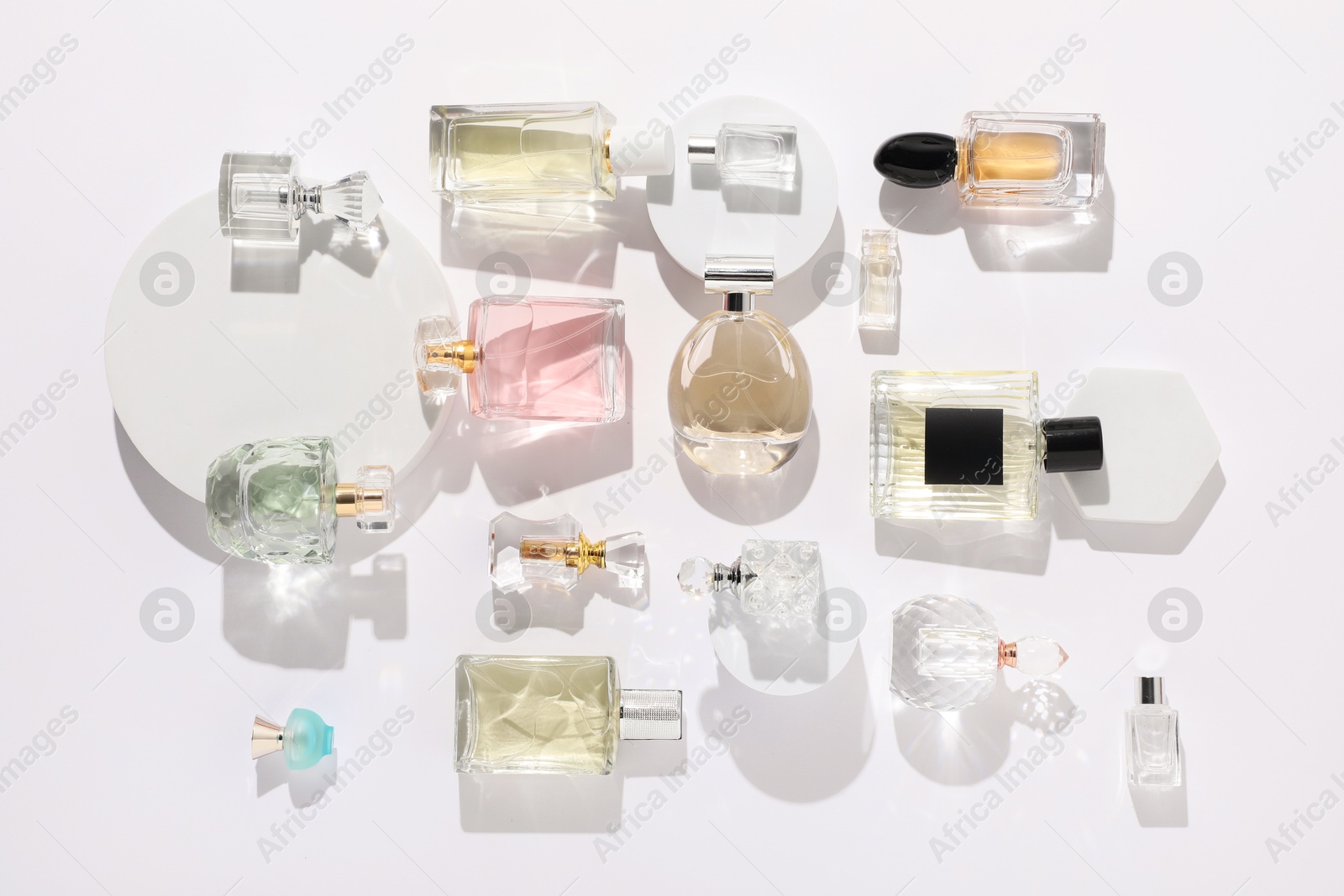 Different luxury perfumes on white background, flat lay Photo of Different luxury perfumes on white background, flat lay