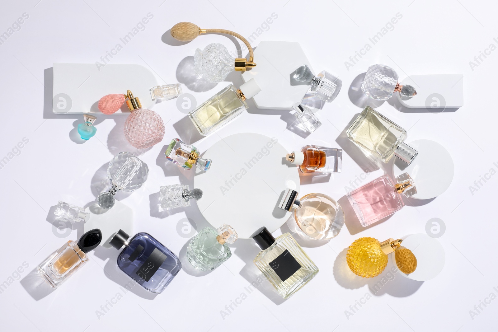 Different luxury perfumes on white background, flat lay Photo of Different luxury perfumes on white background, flat lay