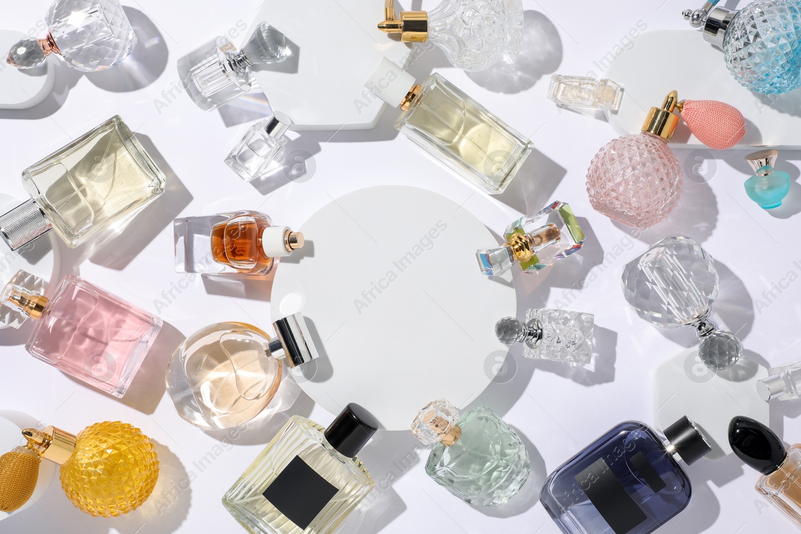 Different luxury perfumes on white background, flat lay Photo of Different luxury perfumes on white background, flat lay