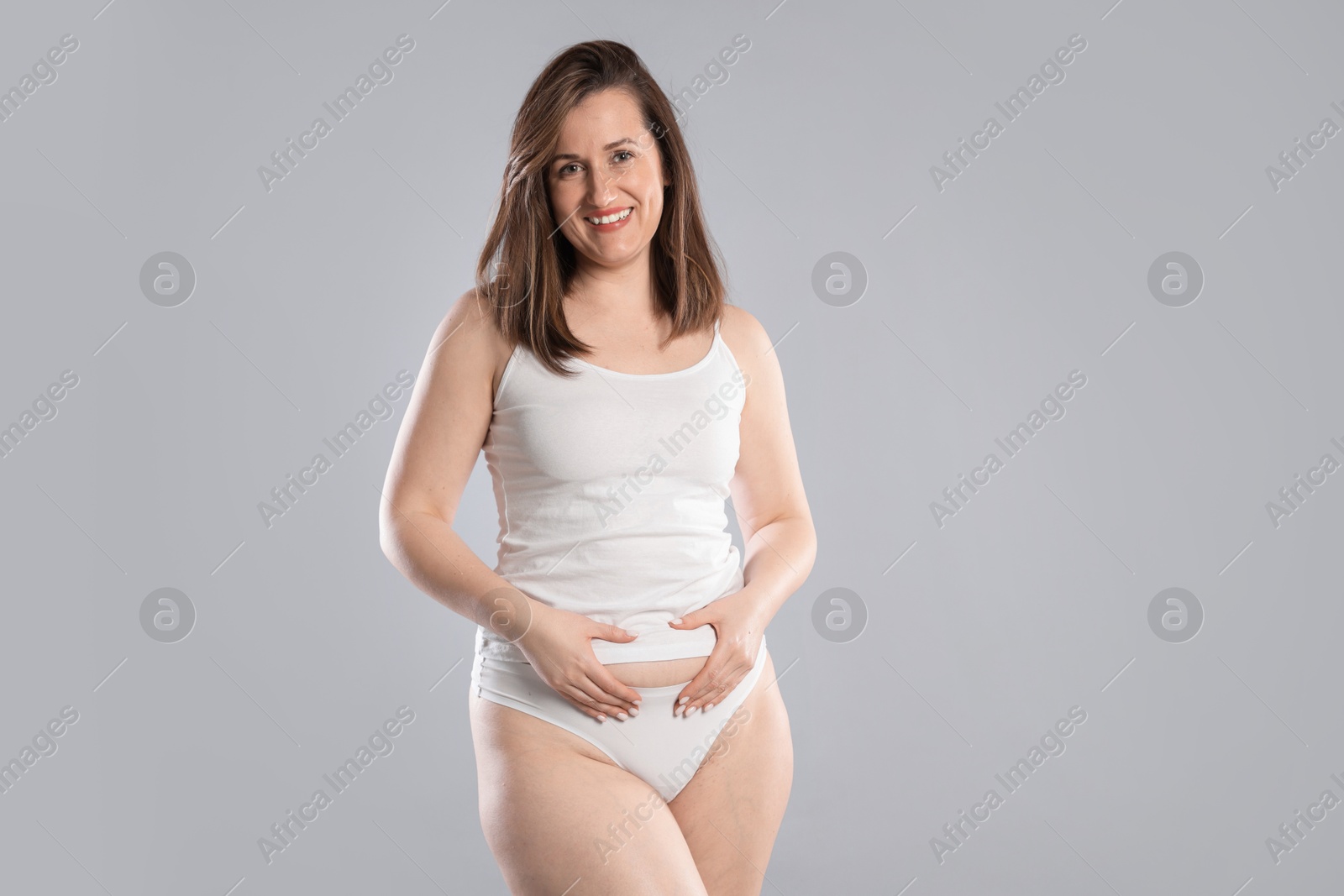 Photo of Woman in underwear on light grey background. Cellulite problem