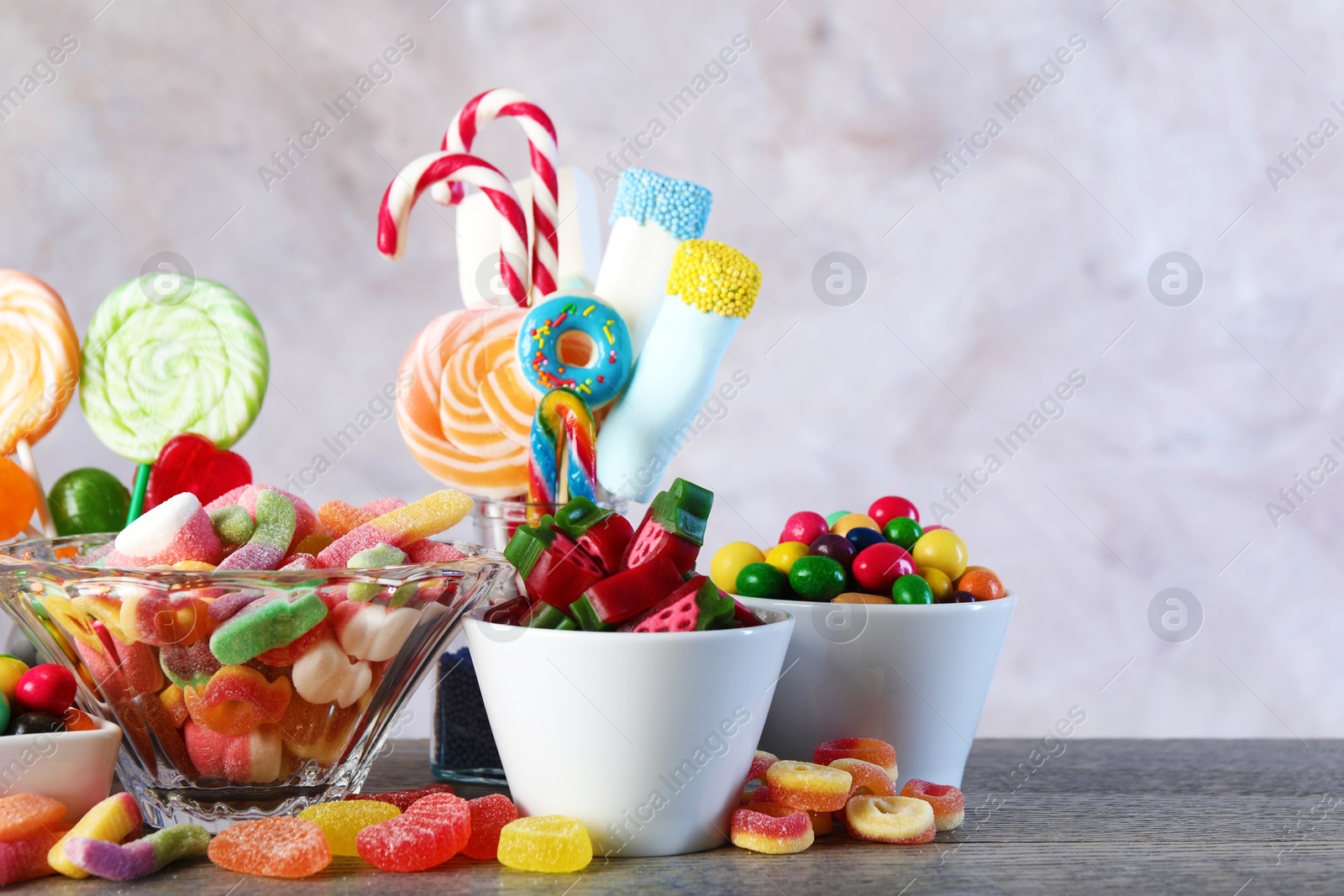 Photo of Candy bar. Many different sweets on wooden table against grey background. Space for text