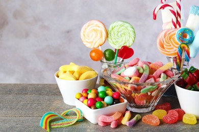 Candy bar. Many different sweets on wooden table against grey background. Space for text