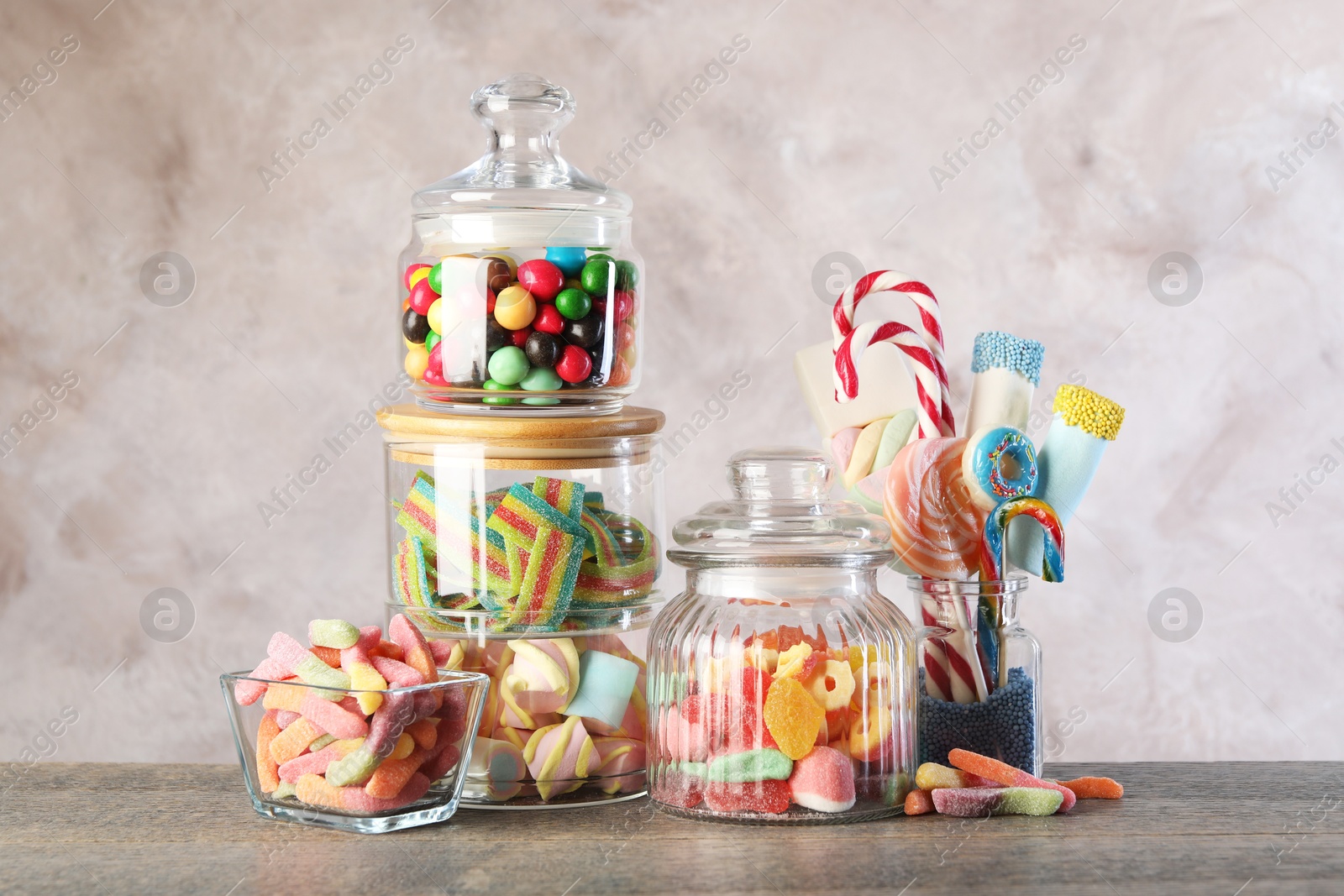 Photo of Candy bar. Many different sweets on wooden table against grey background