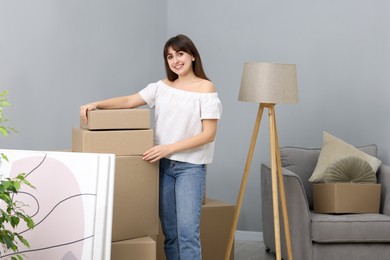 Photo of Moving day. Happy woman with her belongings in new home