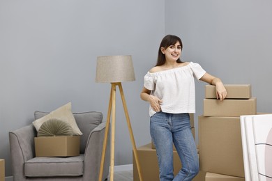 Moving day. Happy woman with her belongings in new home