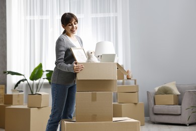 Moving day. Happy woman with her belongings in new home