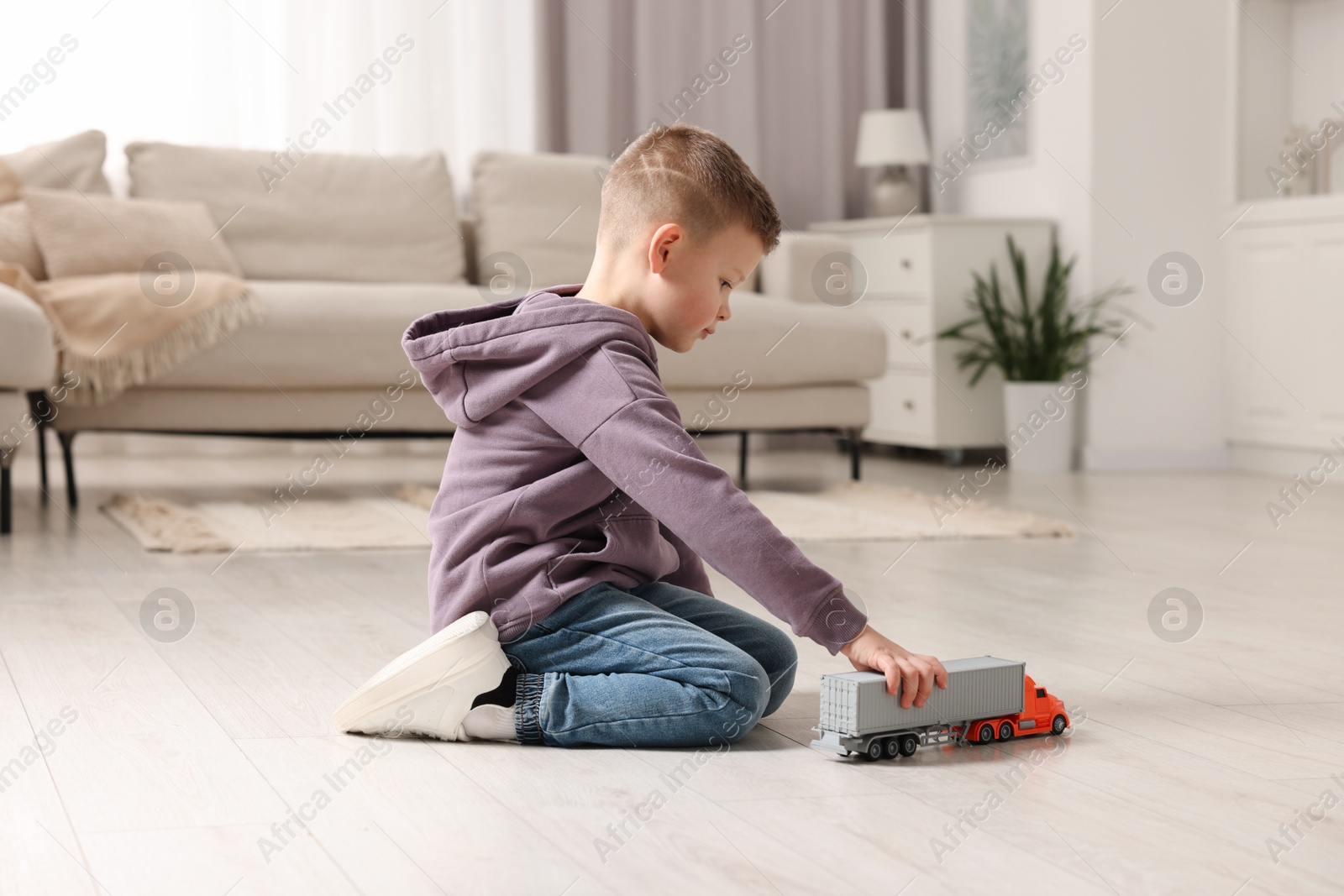 Photo of Little boy playing with toy car at home