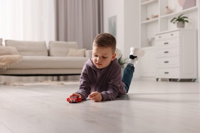 Little boy playing with toy car at home