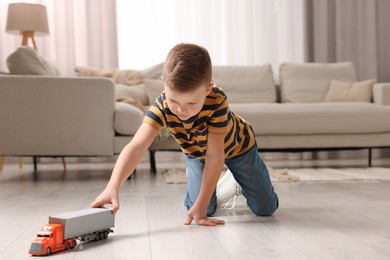 Little boy playing with toy car at home