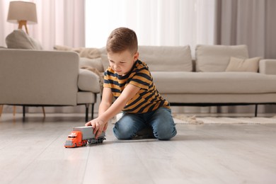 Photo of Little boy playing with toy car at home