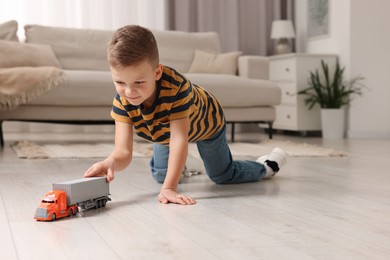 Little boy playing with toy car at home