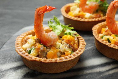 Photo of Tartlets with delicious filling on table, closeup