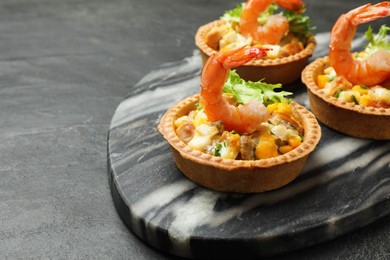 Photo of Tartlets with delicious filling on black table, closeup. Space for text