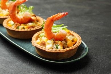 Photo of Tartlets with delicious filling on black table, closeup