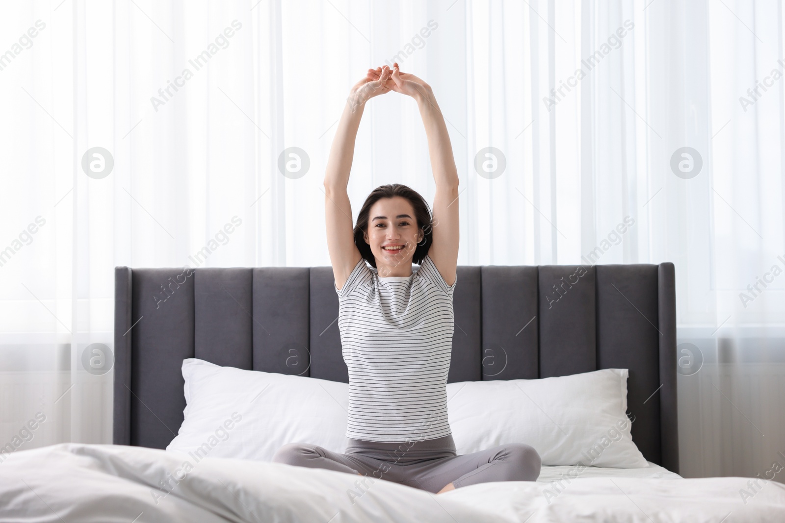 Photo of Young woman exercising on bed at home. Morning routine