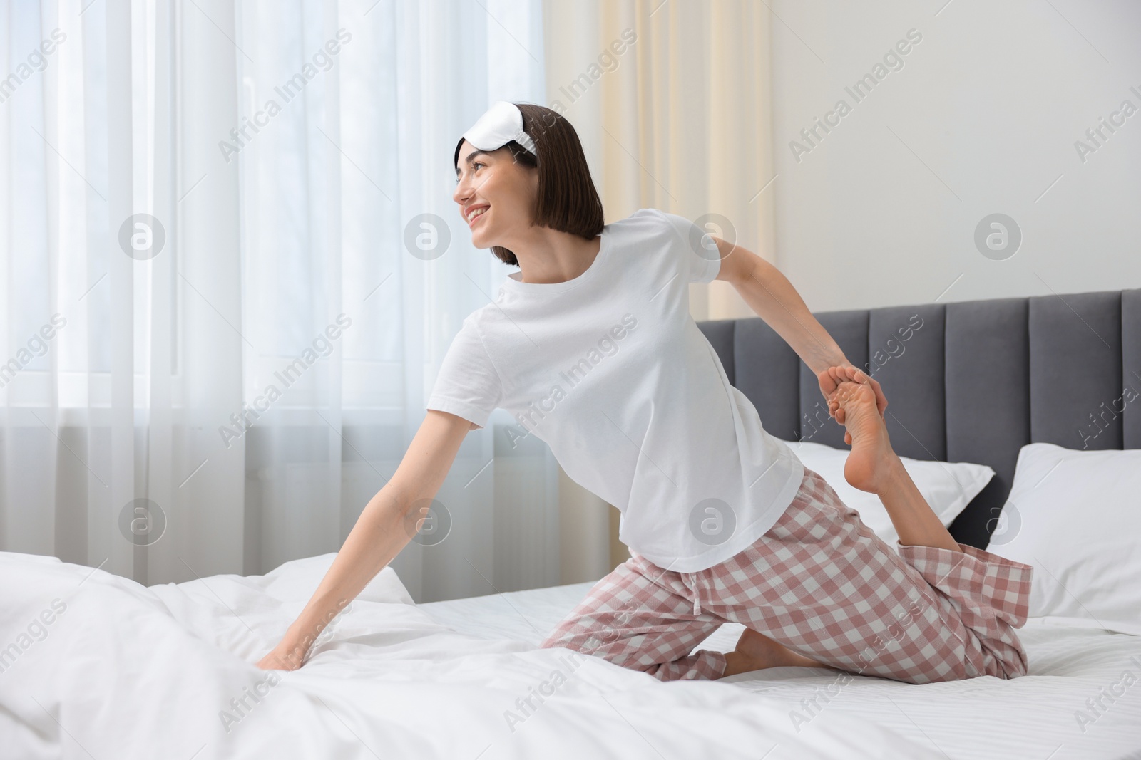 Photo of Young woman exercising on bed at home. Morning routine