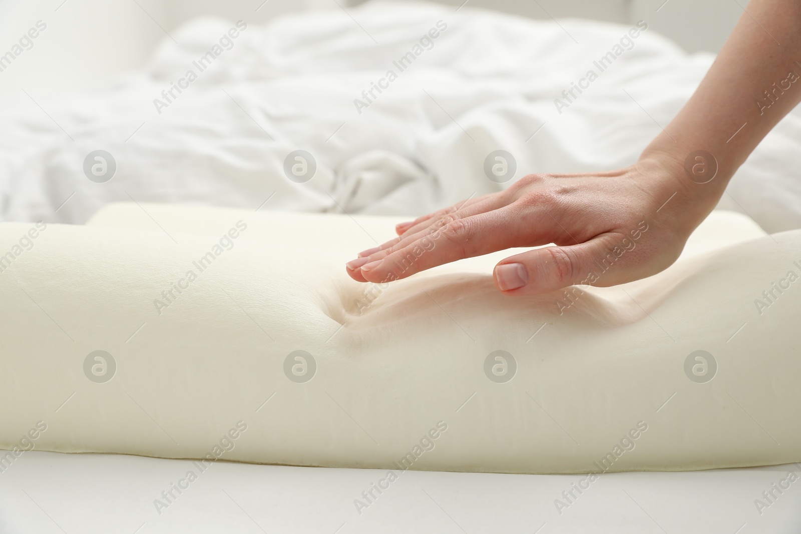 Photo of Woman with orthopedic memory foam pillow on bed, closeup. Space for text