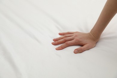 Photo of Woman touching orthopedic mattress, closeup. Space for text