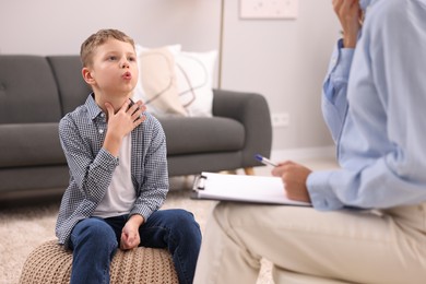 Dyslexia treatment. Speech therapist working with boy in room