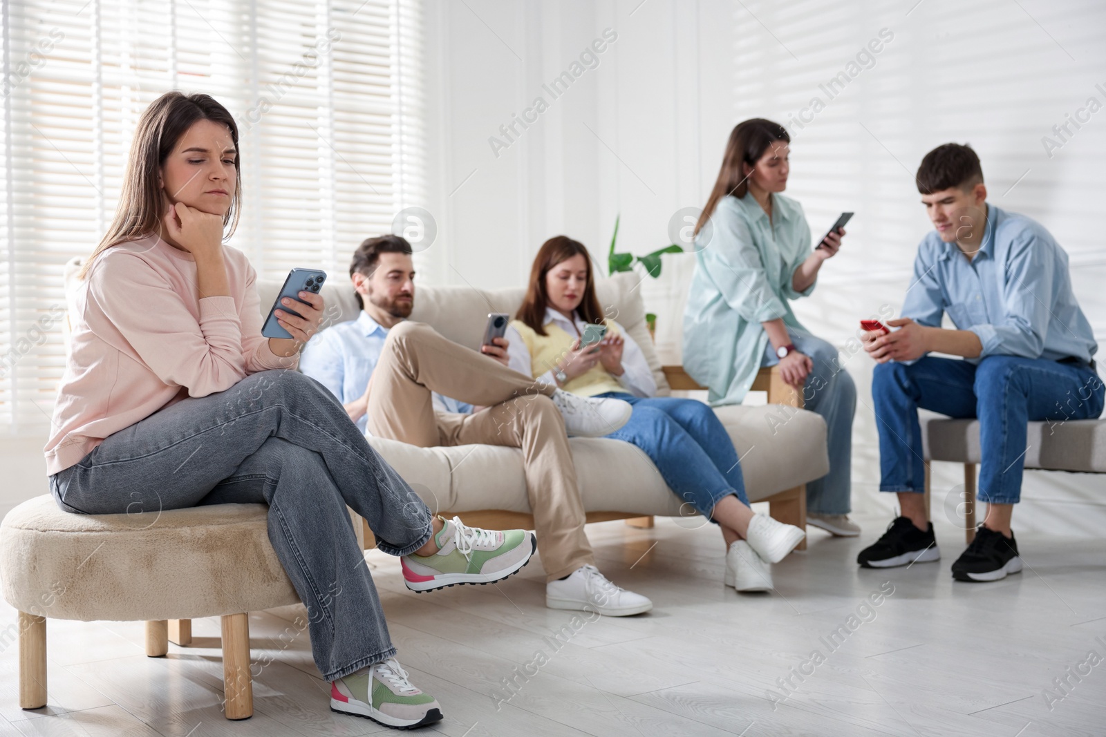 Photo of Internet addiction. Group of people with smartphones on sofa indoors