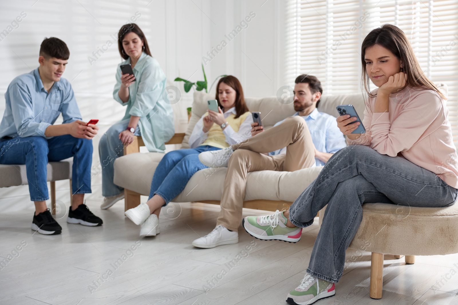 Photo of Internet addiction. Group of people with smartphones on sofa indoors