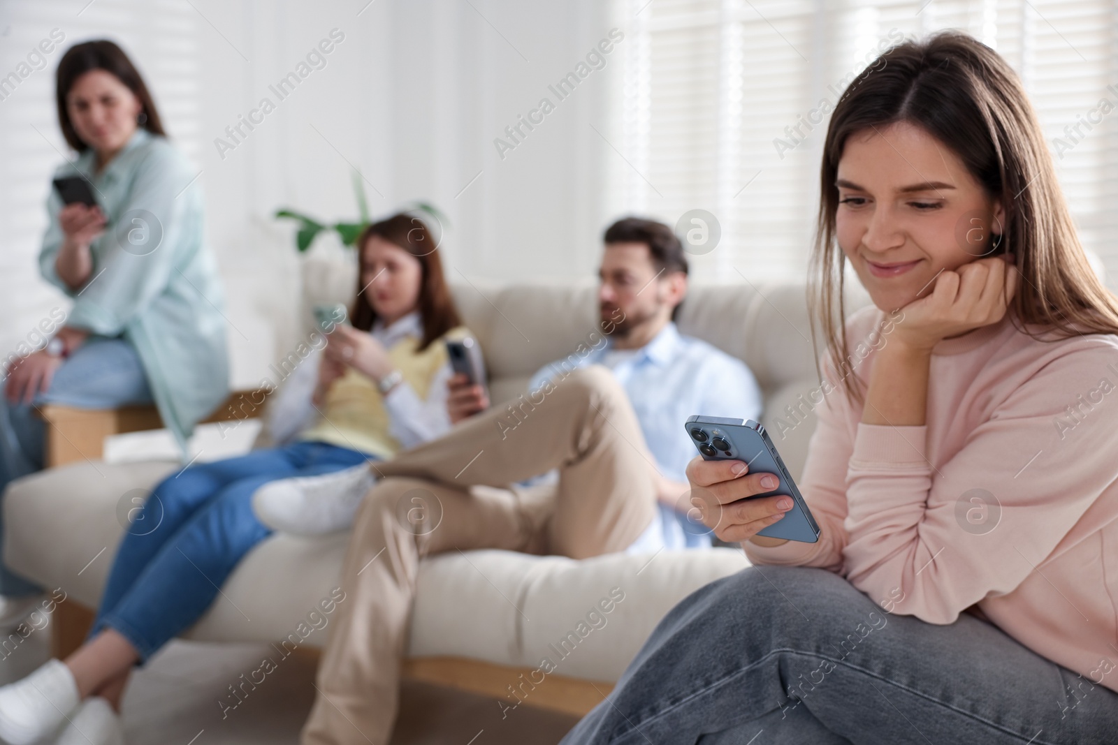 Photo of Internet addiction. Group of people with smartphones on sofa indoors, selective focus