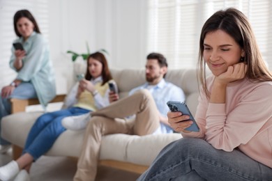 Internet addiction. Group of people with smartphones on sofa indoors, selective focus