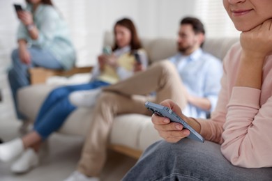 Photo of Internet addiction. Group of people with smartphones on sofa indoors, selective focus