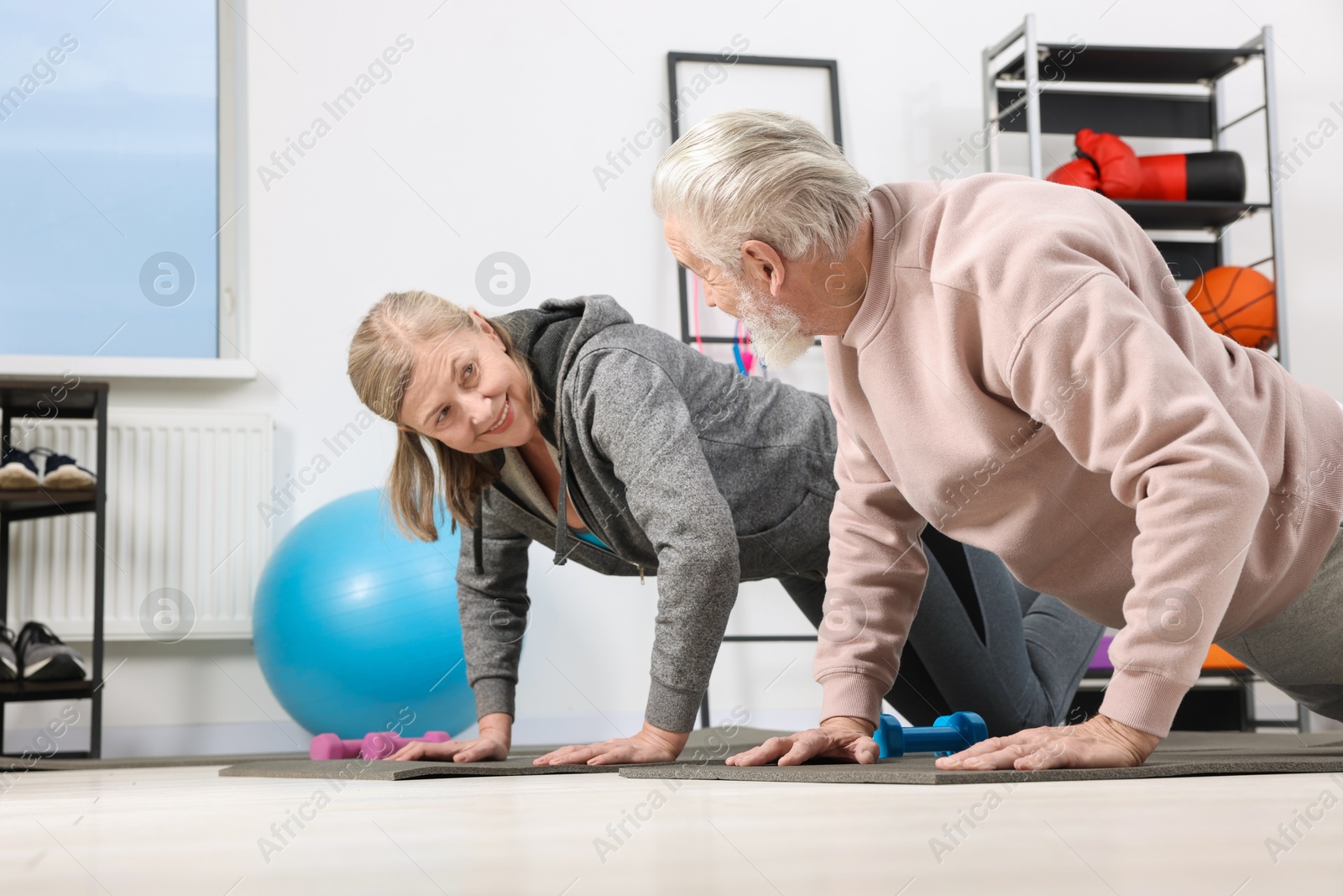 Photo of Elderly couple exercising at home. Healthy leisure