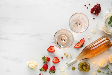 Photo of Flat lay composition with tasty rose wine and different food on white marble table. Space for text