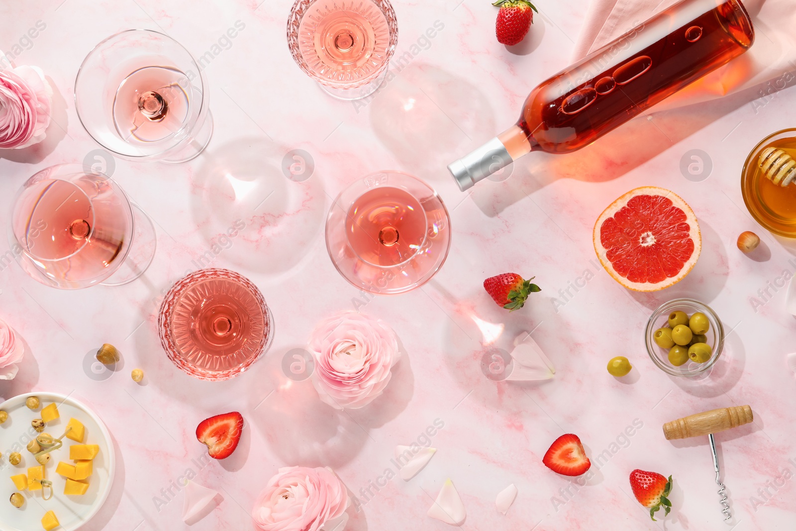 Photo of Flat lay composition with tasty rose wine and different food on pink marble table