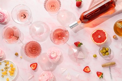 Flat lay composition with tasty rose wine and different food on pink marble table