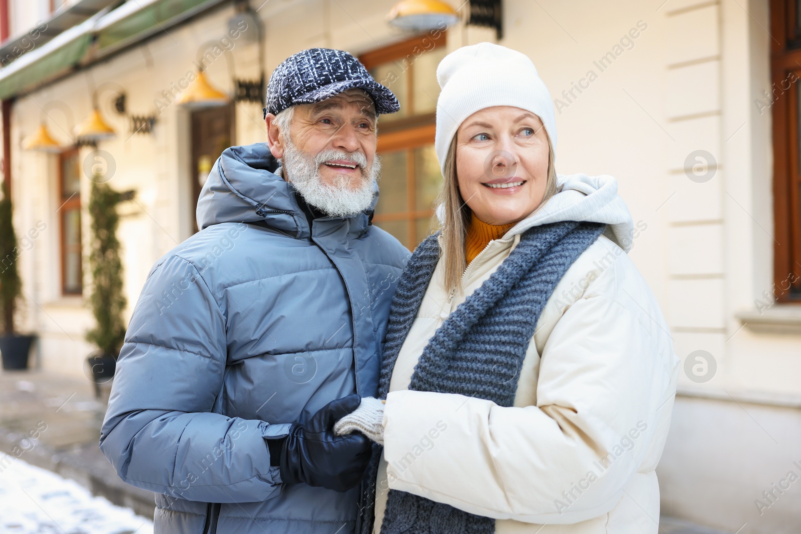 Photo of Happy elderly couple holding hands on city street