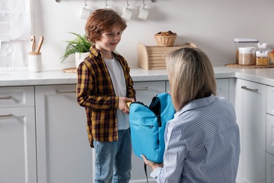 Mother packing her son's lunch in kitchen