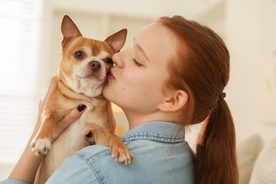 Photo of Teenage girl with her cute Chihuahua dog at home, closeup