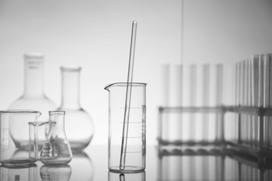 Laboratory glassware on mirror surface against light background