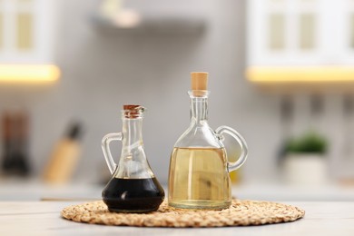 Photo of Bottles of salad dressings on white table in kitchen