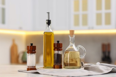 Photo of Bottles of salad dressings, salt and pepper on white table in kitchen