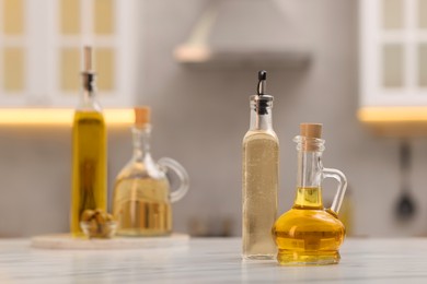 Photo of Bottles of salad dressings on white table in kitchen, space for text