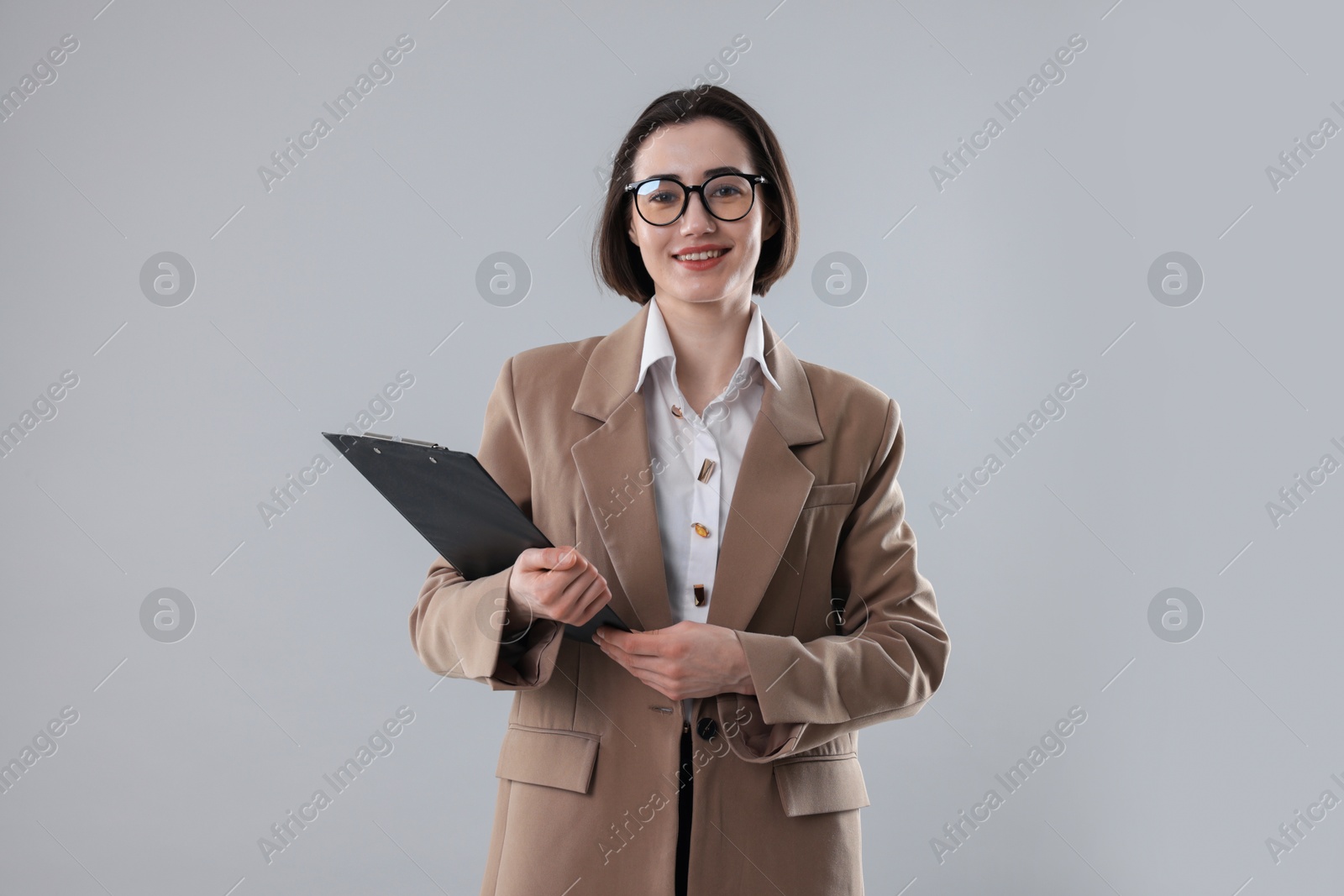 Photo of Portrait of young secretary with clipboard on grey background