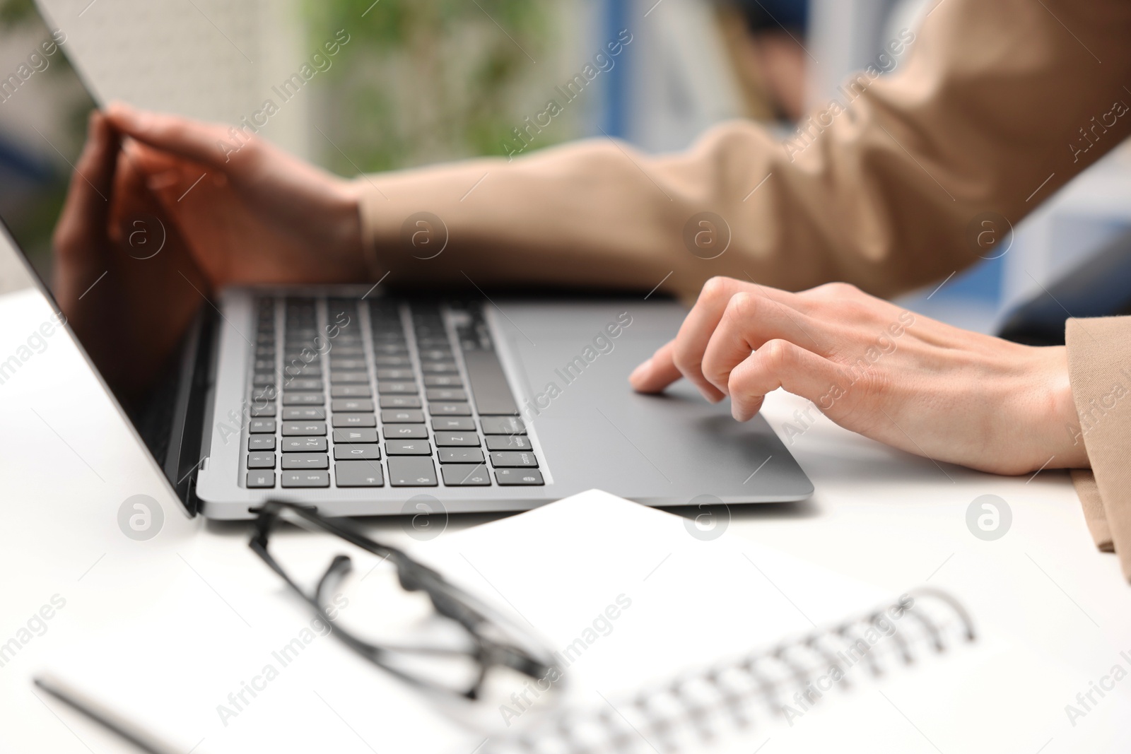 Photo of Secretary working on laptop at table in office, closeup