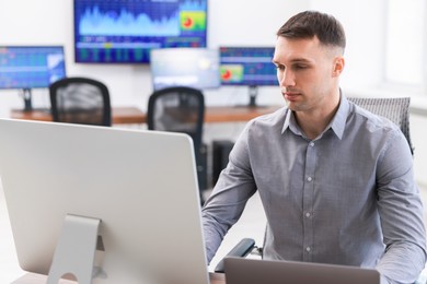 Photo of Financial trading specialist working on computer in office