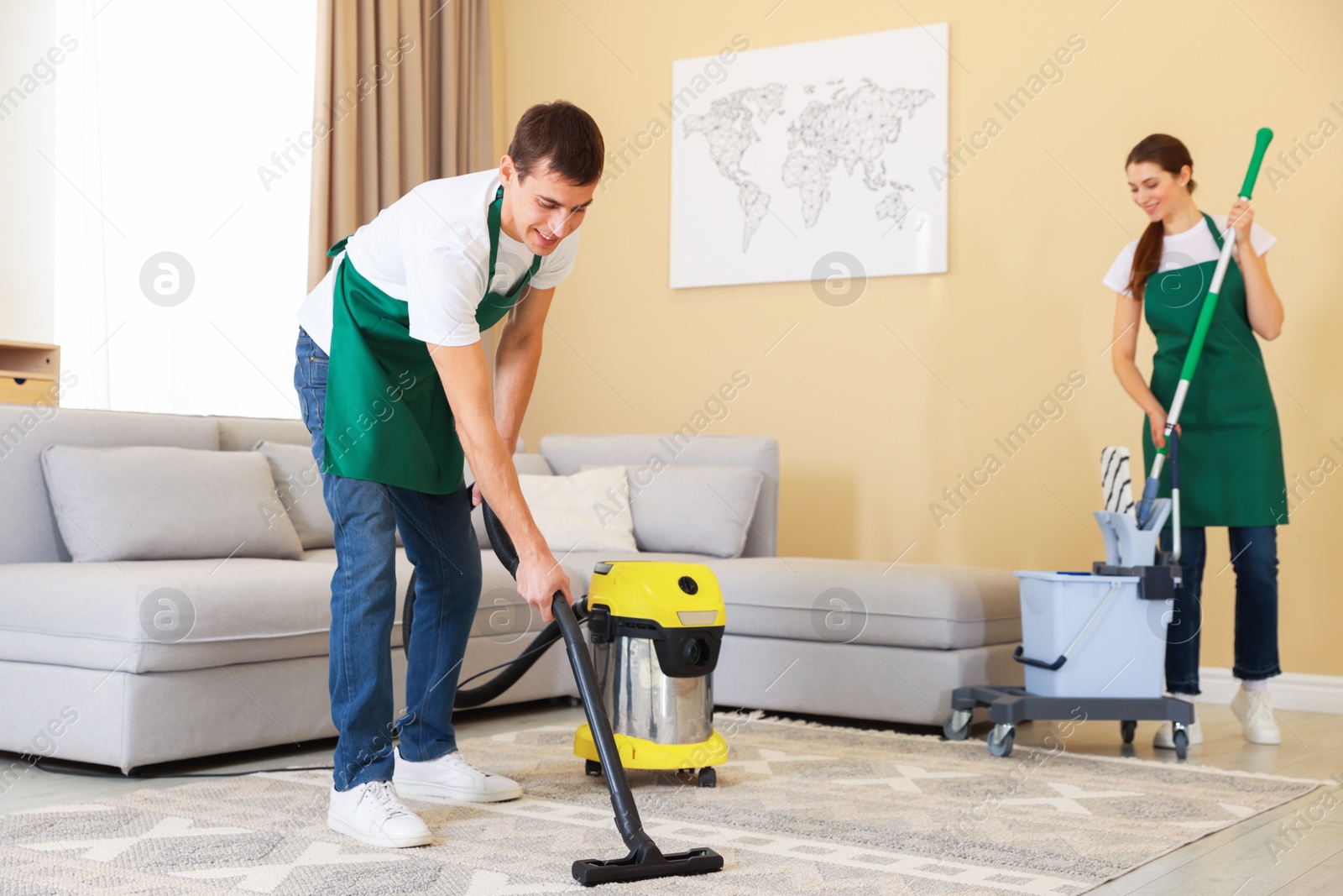 Photo of Professional cleaning service team working in room