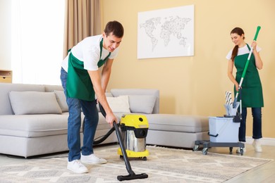 Photo of Professional cleaning service team working in room