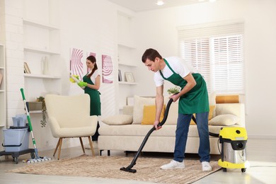 Professional cleaning service team working in room